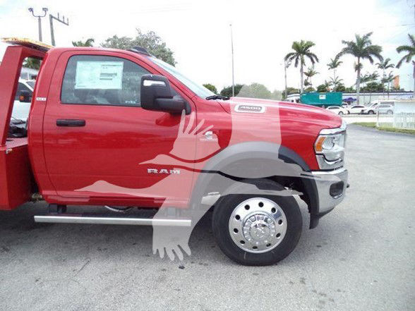 Side view of a red Ram 4500 pickup truck showing 'RAM' emblem on door and truck body, with front fender, wheel, and side mirror visible.