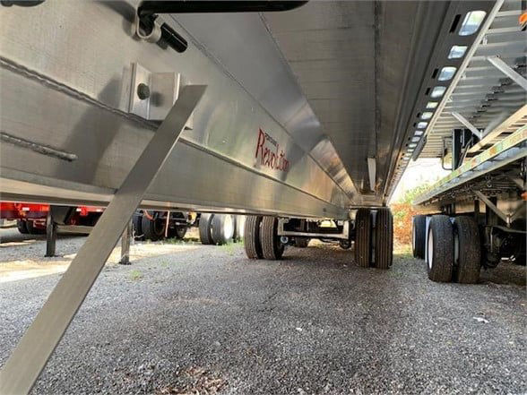 Flatbed trailer undercarriage showing aluminum frame and wheels, Fontaine All Aluminum 48ft trailer details visible