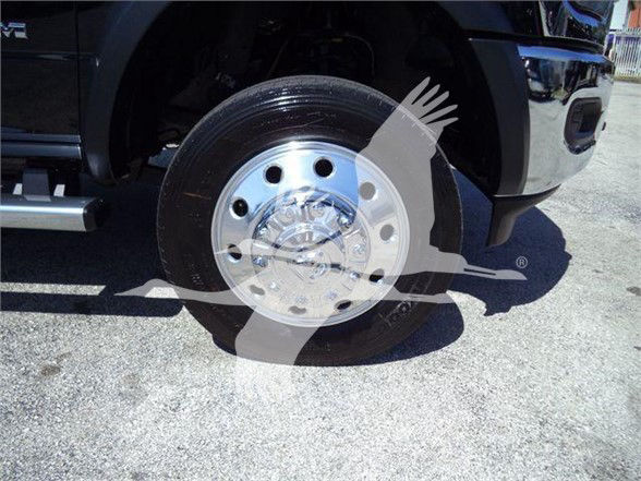 Ram 5500 wheel and tire with chrome hubcap, front bumper visible; faint watermark overlay across wheel.