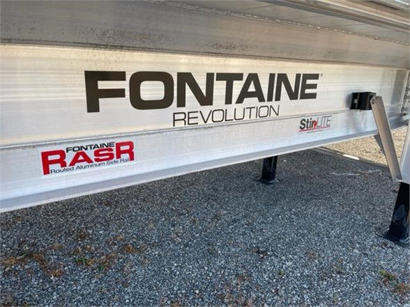 Fontaine Revolution logo on aluminum flatbed trailer side with 'StirLIFE' sticker and RABR logo, support jack leg visible, gravel ground.