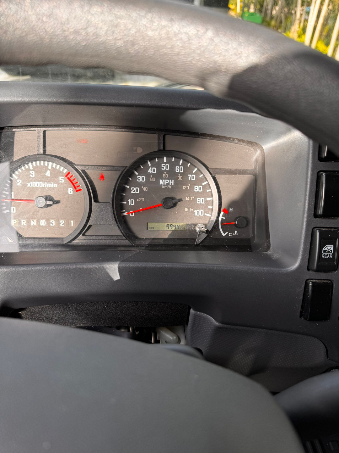 Isuzu NQR dashboard showing tachometer and speedometer with odometer readout and warning lights.