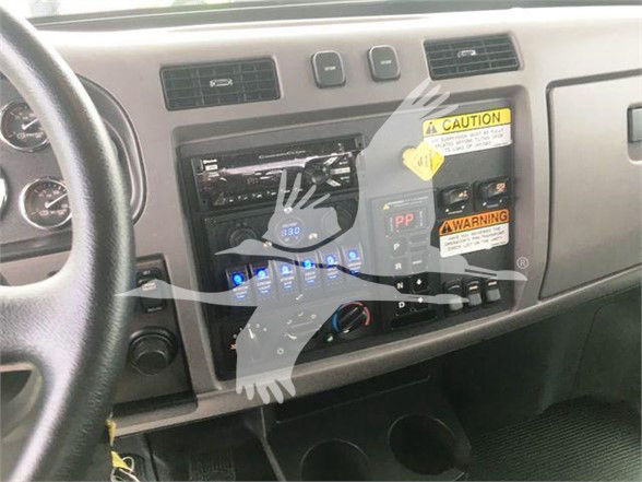 Peterbilt 337 truck interior dashboard showing center stack with radio, climate vents, and warning stickers on the dash.
