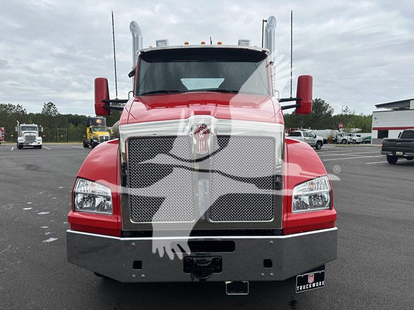Front view of a red Kenworth T880 truck in a dealership lot showing large grille, headlights, and bumper with chrome accents.
