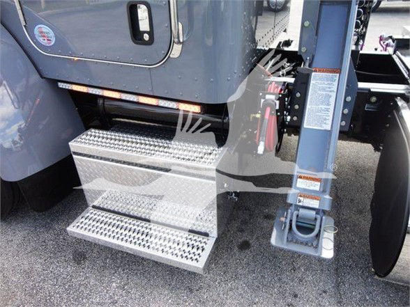 Peterbilt 337 truck side steps and front frame with metal diamond plate steps near entry door.