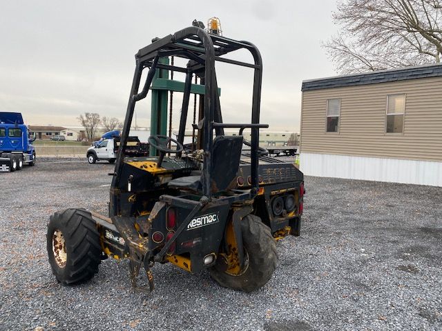 Kesmac F5000 forklift truck in-service with black and yellow frame, rear view showing tires, mast, and operator seat.
