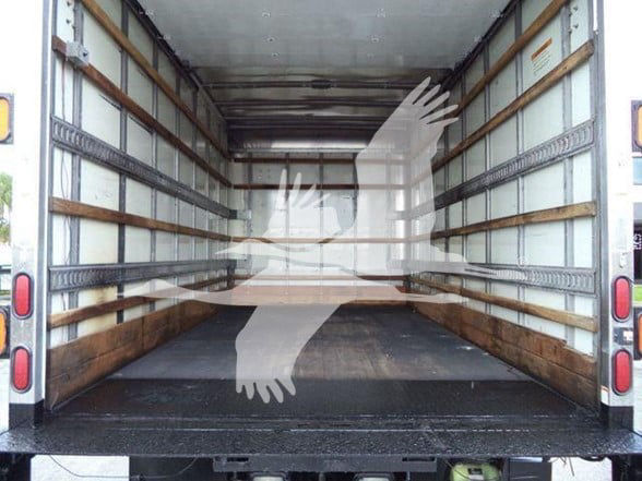 Isuzu NPR-HD box truck interior showing empty cargo area with wooden side rails and metal floor and rear doors.