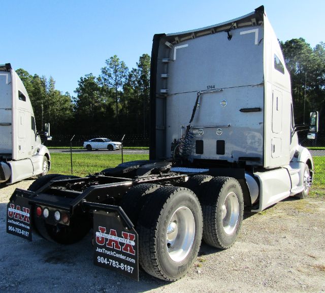Kenworth T680 cab and chassis truck rear view showing fifth wheel, dual rear axles, and cab aerodynamic shape.