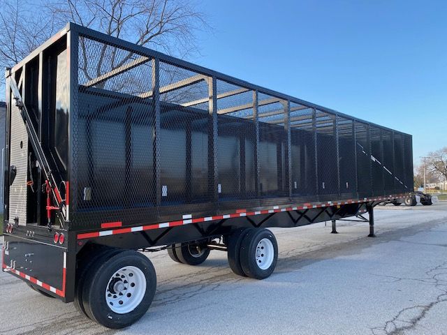 Transcraft 48 ft crush car carrier trailer in black with mesh sides, dual rear axles, and support jacks.
