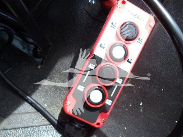 Control panel with three circular knobs and switches on red housing; labels around knobs; appears to be a truck equipment control panel.