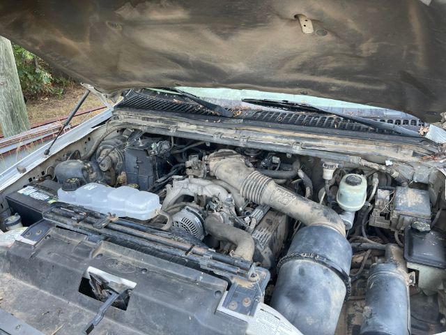 Ford F-450 engine bay with hood open, showing air intake, battery, coolant reservoir, and various hoses; VIN 3FDXF46S5XMA17764 not visible.