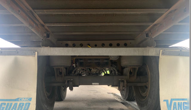 Underbody view of a Vanguard VXP trailer showing suspension, axles, and frame from rear, with CDL ramps and undercarriage components visible.