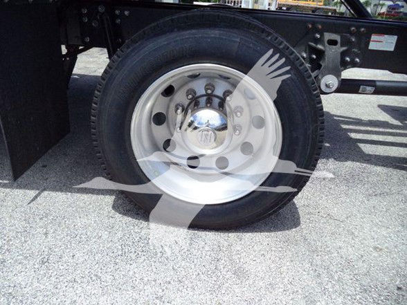 Wheel of a 2025 Hino L6 tow truck showing a white steel rim, tire, and part of the chassis.