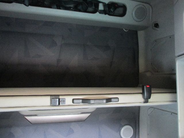 Volvo 780 sleeper cab interior storage bunk with upper and lower compartments, partition, and seat belt buckle visible.