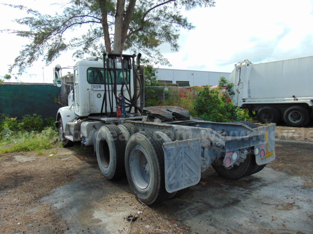 Peterbilt 365 cab and chassis rear view showing dual rear axles and fifth-wheel mounting area with mud flaps and chain lines.