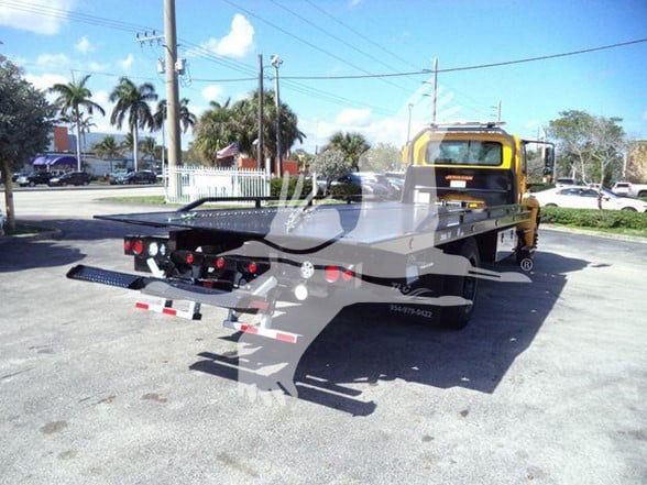 2019 International DURASTAR 4300 flatbed tow truck rear and side view showing heavy-duty tilt-bed with ramps and rear lighting.