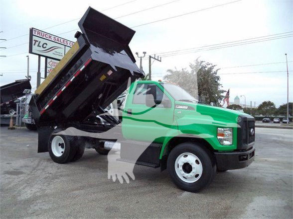 2017 Ford F650 SD dump truck with bed raised showing dump body and green cab.