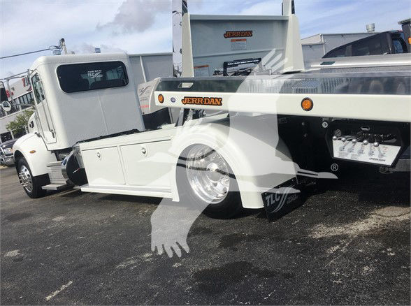 Peterbilt 337 tow truck side view showing wheel, white paint, and Jerr-Dan tow body.