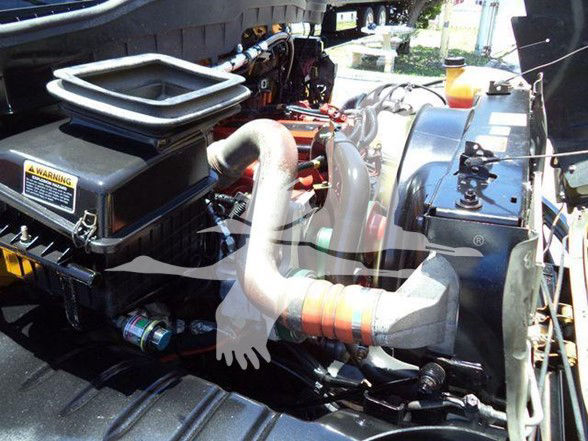 Truck engine bay showing air intake and coolant reservoir in a 2019 International DURASTAR 4300 chassis with visible hoses and components.