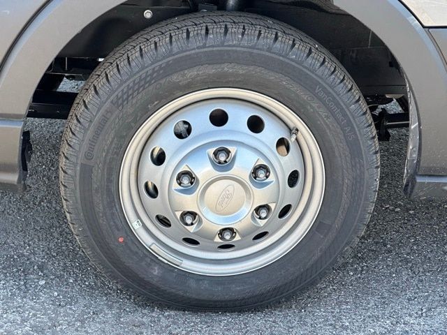 Wheel close-up on a 2023 Ford Transit 350 box truck showing a steel rim and tire with Ford center cap.