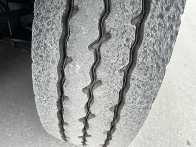 Close-up of a truck tire tread showing multiple grooves and wear marks.