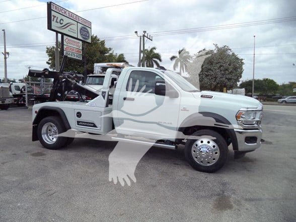 2024 Ram 4500 SLT tow truck side view with crane/flatbed setup in a dealership lot.