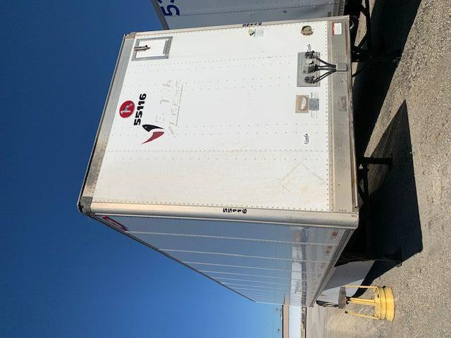 Trailer rear view with white Great Dane Champion trailer, vertical seams, and registration numbers visible on back doors.