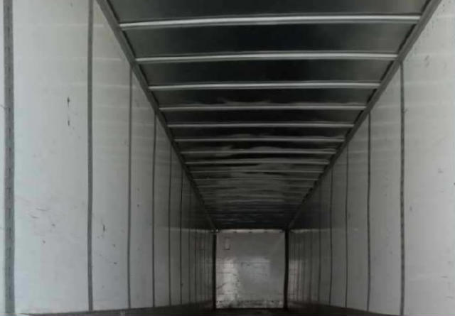 Trailer interior showing longitudinal steel side walls and roof ribs, empty cargo space.