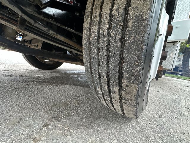 Truck front wheel with dual-tire setup and undercarriage visible.