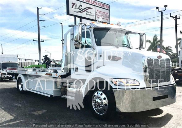 Peterbilt 337 tow truck in white with chrome bumper and dual rear wheels, front grille and cab details visible.