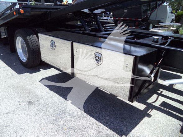 Two metal storage boxes mounted under a heavy-duty truck frame with circular recessed latches and polished faces.