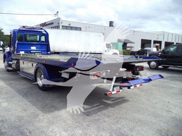 Kenworth T280 tow truck flatbed rear view showing hydraulic tilt bed and loading ramps.