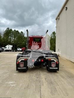 Kenworth T880 rear view showing fifth wheel and dual rear tires in yard.