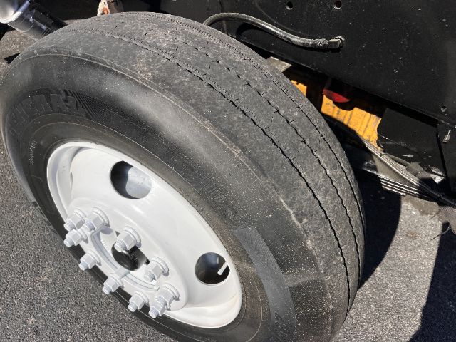 Truck rear wheel and axle assembly with dual tires and hub shown; no legible labels or serials visible in this close-up.