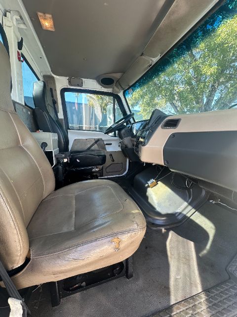 Operator seat and dashboard of a 2006 Sterling L8500 vacuum truck interior showing driver seat, steering wheel, and control panel.