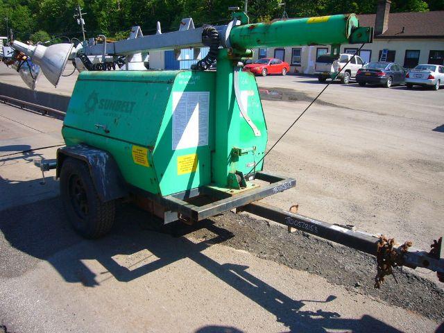 Terex AL4060D1-S-4MH light-green mounted boom trailer with trailer hitch and long support bar. Visible text includes Suncrest logo on the side and yellow warning labels.