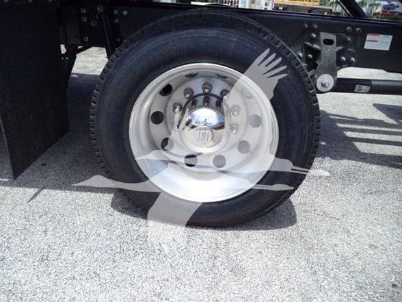 Wheel and tire assembly of a 2025 Hino L6 chassis showing alloy rim and tire mounted on the rear of a tow truck chassis.
