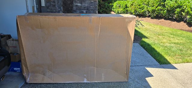 Large cardboard box in driveway. No visible labels or branding on the box.
