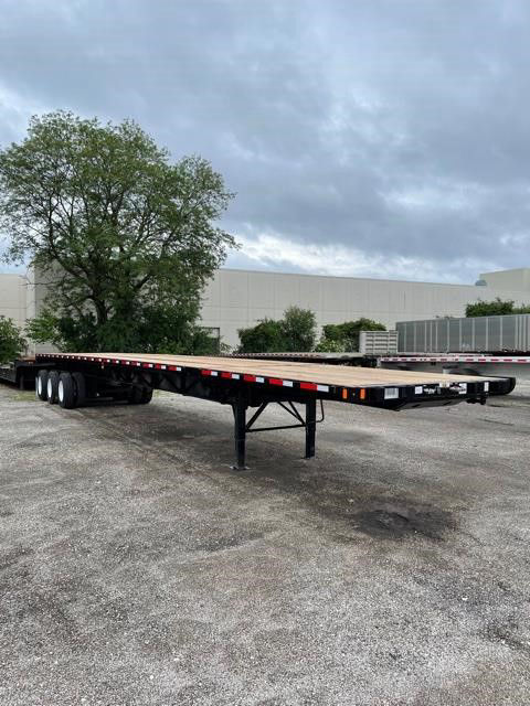 Flatbed trailer showing extendable all-steel construction with multiple axles and a long deck.
