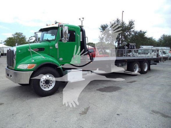 Green 2016 Peterbilt 348 tow truck with flatbed, front left view, stock image with watermark overlay.