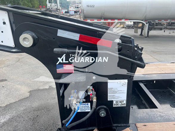 XL Guardian branded hydraulic lift support of XL Specialized XL110Hdgs trailer with warning labels and hoses visible.