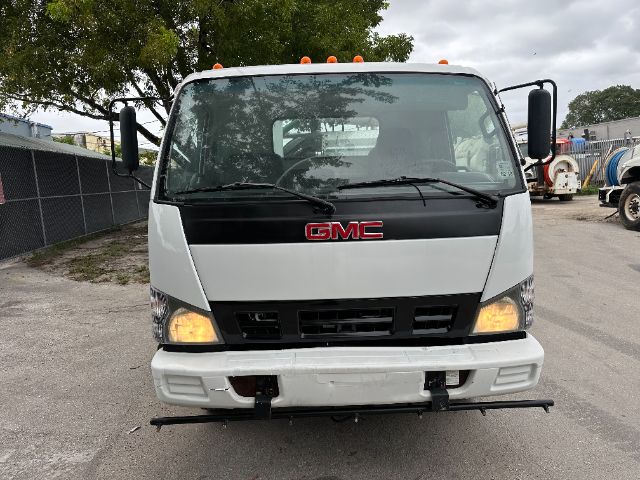 GMC W5500 cab front view showing GMC emblem, headlights, front bumper, and roof clearance lights.