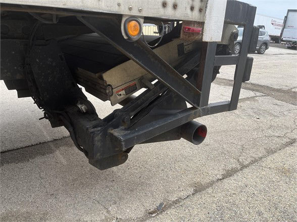 Rear corner of a Wabash dry van trailer showing bumper hitch and frame with a circular red taillight lens and rear support structure.