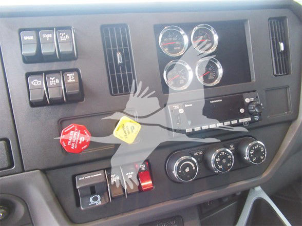 Kenworth T480 truck dash panel showing gauges, switches, climate controls, and ignition area.
