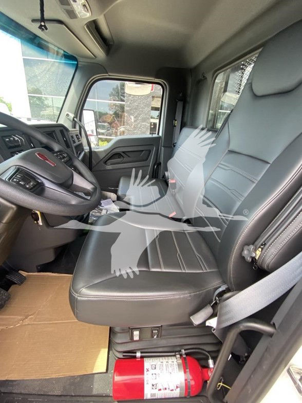 Kenworth T480 truck interior showing black leather driver seat and passenger seat, steering wheel, dashboard, and safety equipment; fire extinguisher under seat.
