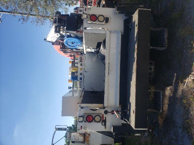 Rear view of a white Ford F550 service truck with a mounted crane and tool compartments.