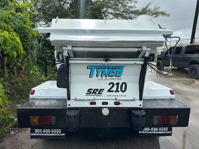 Isuzu NPR-HD street sweeper rear view showing TMCO SRE 210 air sweeper unit label.