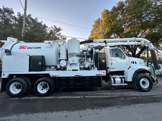 Vacuum truck: 2006 Sterling L8500 with Vac-Con vacuum system and rear pump. Side view shows tank, hoses, and engine bay.