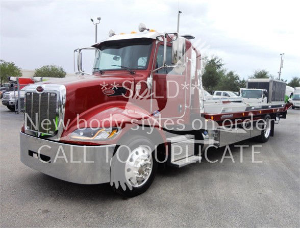 Peterbilt tow truck cab in red with chrome bumper and long flatbed, SOLD watermark and text overlays across image.