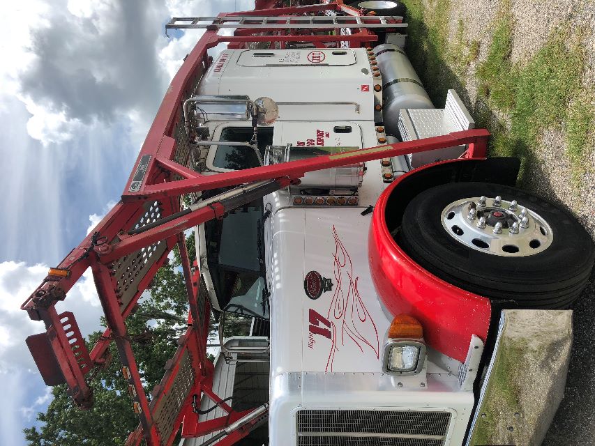 Peterbilt 379 auto carrier truck with red overpass carrier frame and white cab showing '17' on the fender and chrome wheel, side exhaust, and decals.