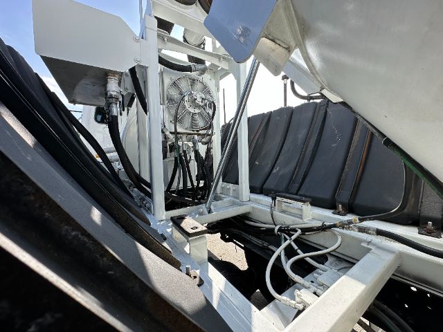 View of Freightliner 108SD chassis with hydraulic hoses, control pedestal, and metal framework in a loading bay.
